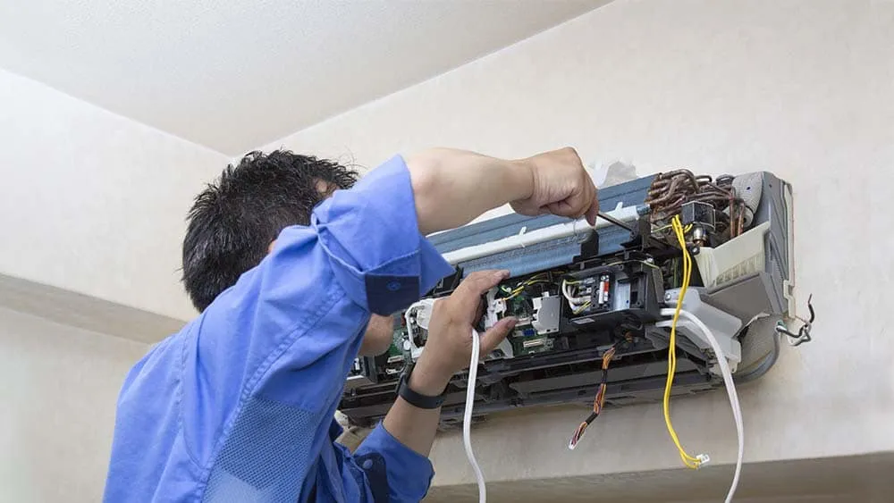 Tampa Bay homeowner checking AC unit for emergency repair signs